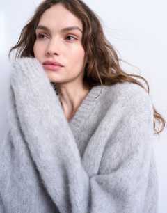 Model wearing Premium knitted fluffy v-neck alpaca jumper in light grey