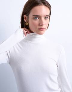 Model wearing Premium rib funnel neck top in ecru