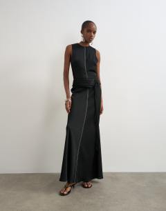 Model wearing Premium satin dropped waist sash detail maxi dress in black with contrast top stitching