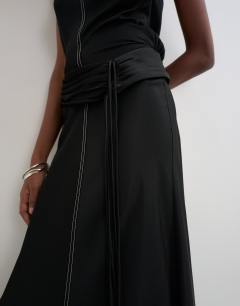 Model wearing Premium satin dropped waist sash detail maxi dress in black with contrast top stitching