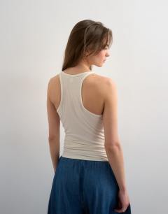 Model wearing Premium semi sheer spaghetti strap scoop racer vest in ecru