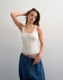 Model wearing Premium semi sheer spaghetti strap scoop racer vest in ecru