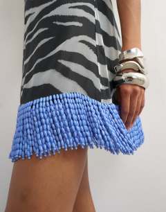 Model wearing Premium sheer low back mini dress with contrast blue embellished hem in mono zebra