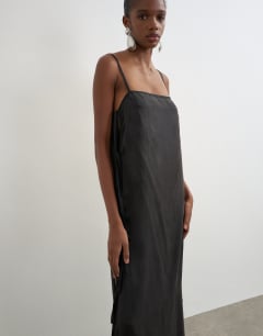 Model wearing Premium silk touch unlined maxi slip dress with satin tie side details in black