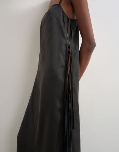 Model wearing Premium silk touch unlined maxi slip dress with satin tie side details in black