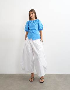 Model wearing Puff sleeve wrap hem detail top in cornflower blue