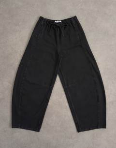 Model wearing Pull on barrel jean in washed black