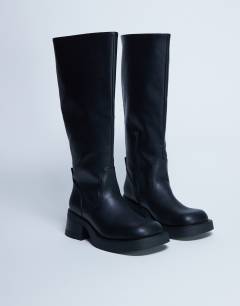Model wearing Rachel knee high chunky heeled boot in black
