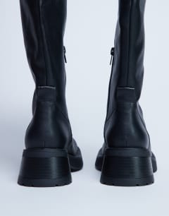 Model wearing Rachel knee high chunky heeled boot in black