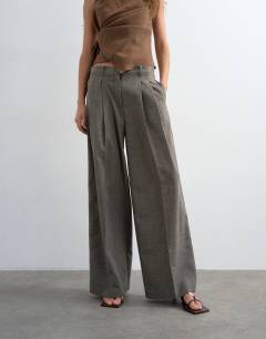 Model wearing Raw hem low slung double pleated tailored trouser in brown marl