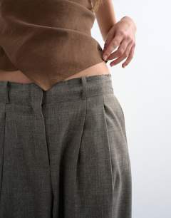 Model wearing Raw hem low slung double pleated tailored trouser in brown marl