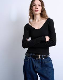 Model wearing Rib v-neck long sleeve curved hem top in black