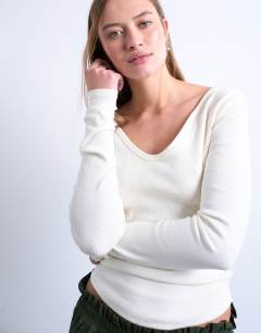 Model wearing Rib v-neck long sleeve curved hem top in ecru