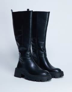 Model wearing Riya knee high chunky boots in black