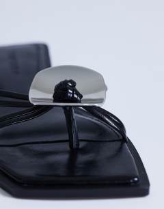 Model wearing Rolo hardware detail flat sandal in black