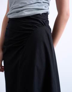 Model wearing Ruched asymmetric midi skirt in black 