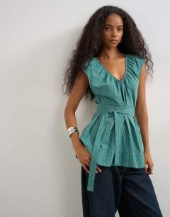 Model wearing Ruched neckline tie detail top in green and blue check