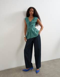 Model wearing Ruched neckline tie detail top in green and blue check