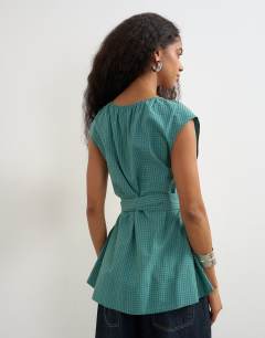 Model wearing Ruched neckline tie detail top in green and blue check