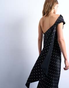 Model wearing Ruched side midi dress with drape back detail in black polka dot