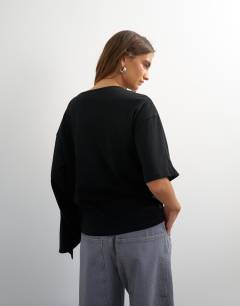 Model wearing Ruffle asymmetric top in black