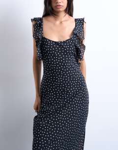 Model wearing Ruffle shoulder amalfi slip dress in black based spot