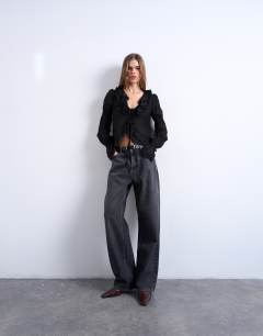 Model wearing Ruffle tie front long sleeve top in black