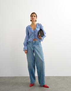 Model wearing Ruffle tie front long sleeve top in pale blue