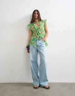 Model wearing Ruffle v neck top in green floral print