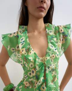 Model wearing Ruffle v neck top in green floral print