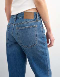 Model wearing Runway mid rise straight cropped jean in vintage blue