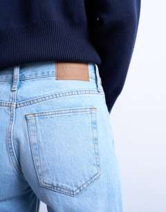 Model wearing Runway mid rise straight cropped jean with let down hem detail in bleach