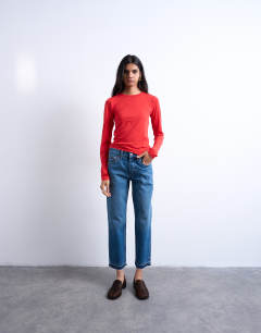Model wearing Runway mid rise straight cropped jean with let down hem detail in mid blue