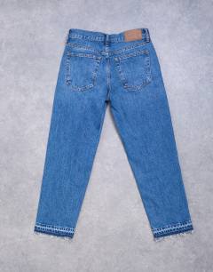 Model wearing Runway mid rise straight cropped jean with let down hem detail in mid blue