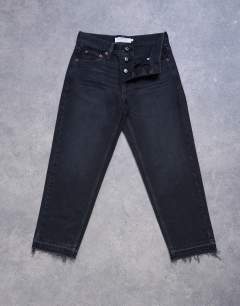 Model wearing Runway mid rise straight cropped jean with let down hem detail in washed black