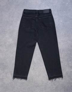 Model wearing Runway mid rise straight cropped jean with let down hem detail in washed black