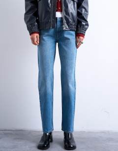 Model wearing Runway mid rise straight jeans in mid blue