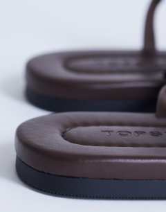 Model wearing Sabrina metal toe flat sandal in chocolate