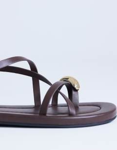 Model wearing Sabrina metal toe flat sandal in chocolate