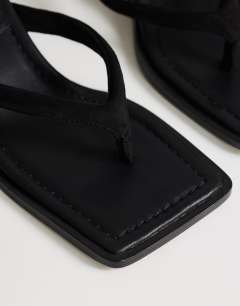Model wearing Sadie toe thong mid heel in black