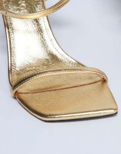 Model wearing Sally 2 part metal heeled sandal in gold