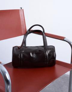 Model wearing Salma bowler bag in chocolate patent