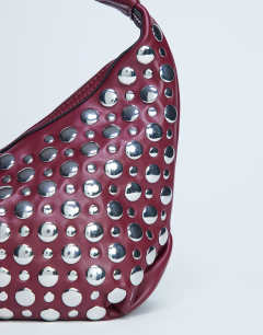 Model wearing Samantha studded shoulder bag in burgundy