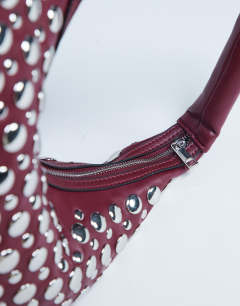 Model wearing Samantha studded shoulder bag in burgundy