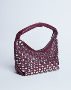 Model wearing Samantha studded shoulder bag in burgundy