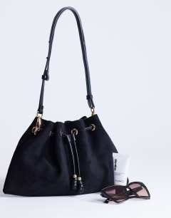 Model wearing Sammy medium ruched drawstring shoulder bag in black