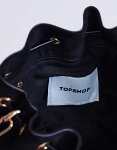 Model wearing Sammy medium ruched drawstring shoulder bag in black