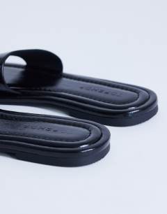 Model wearing Sandra flat sandal mule in black