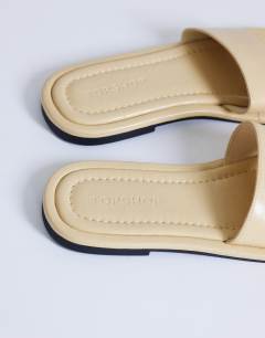 Model wearing Sandra flat sandal mule in buttermilk