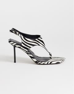 Model wearing Sandy hair on real leather toe thong heeled sandal in black and white zebra